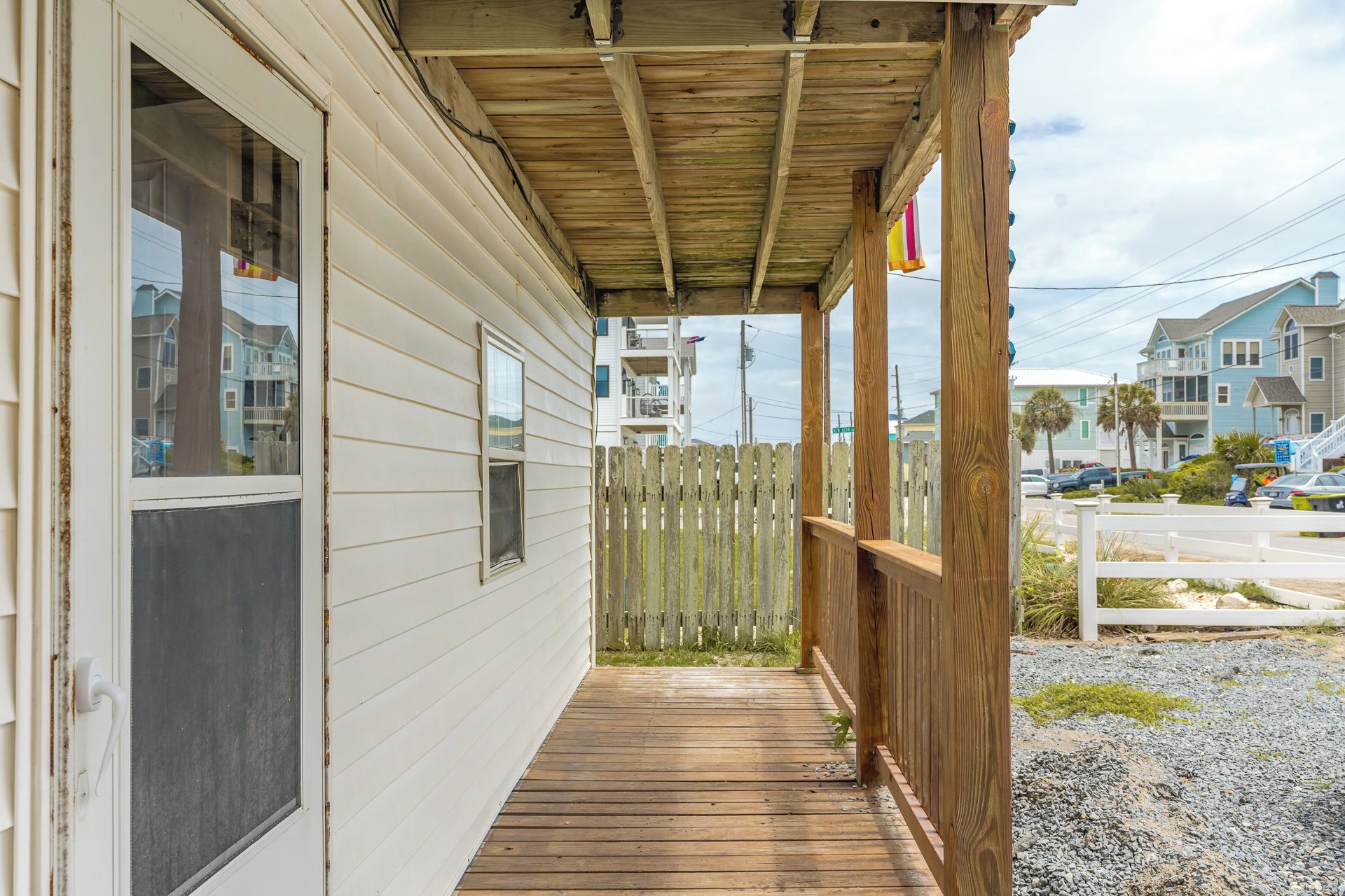 A wooden porch with a view of a residential area.