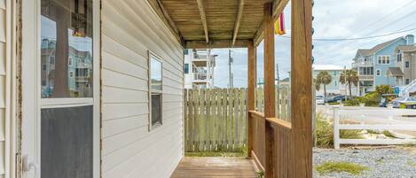 A wooden porch with a view of a residential area.