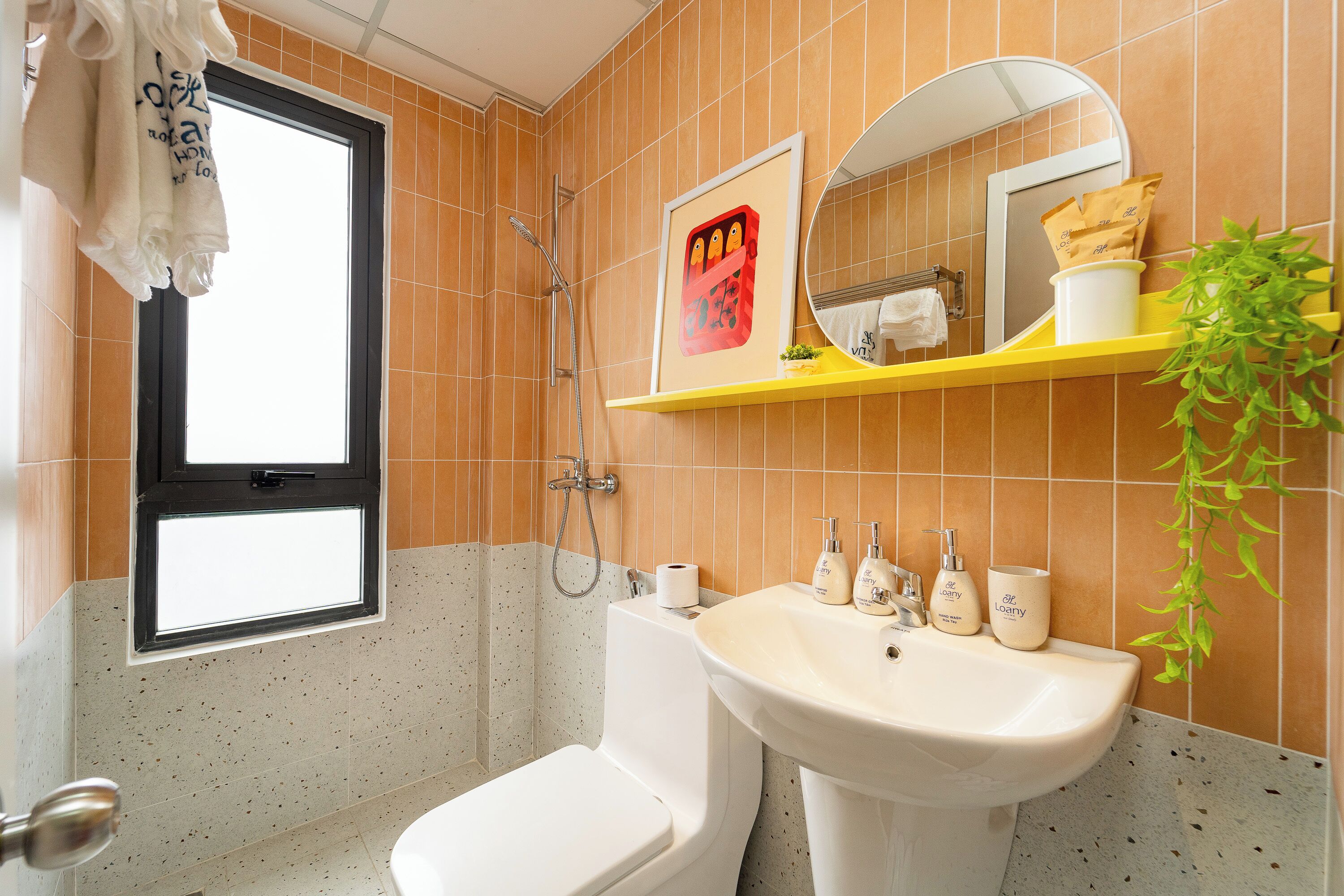 Une salle de bain comprenant des toilettes, un lavabo, une douche et une fenêtre.
