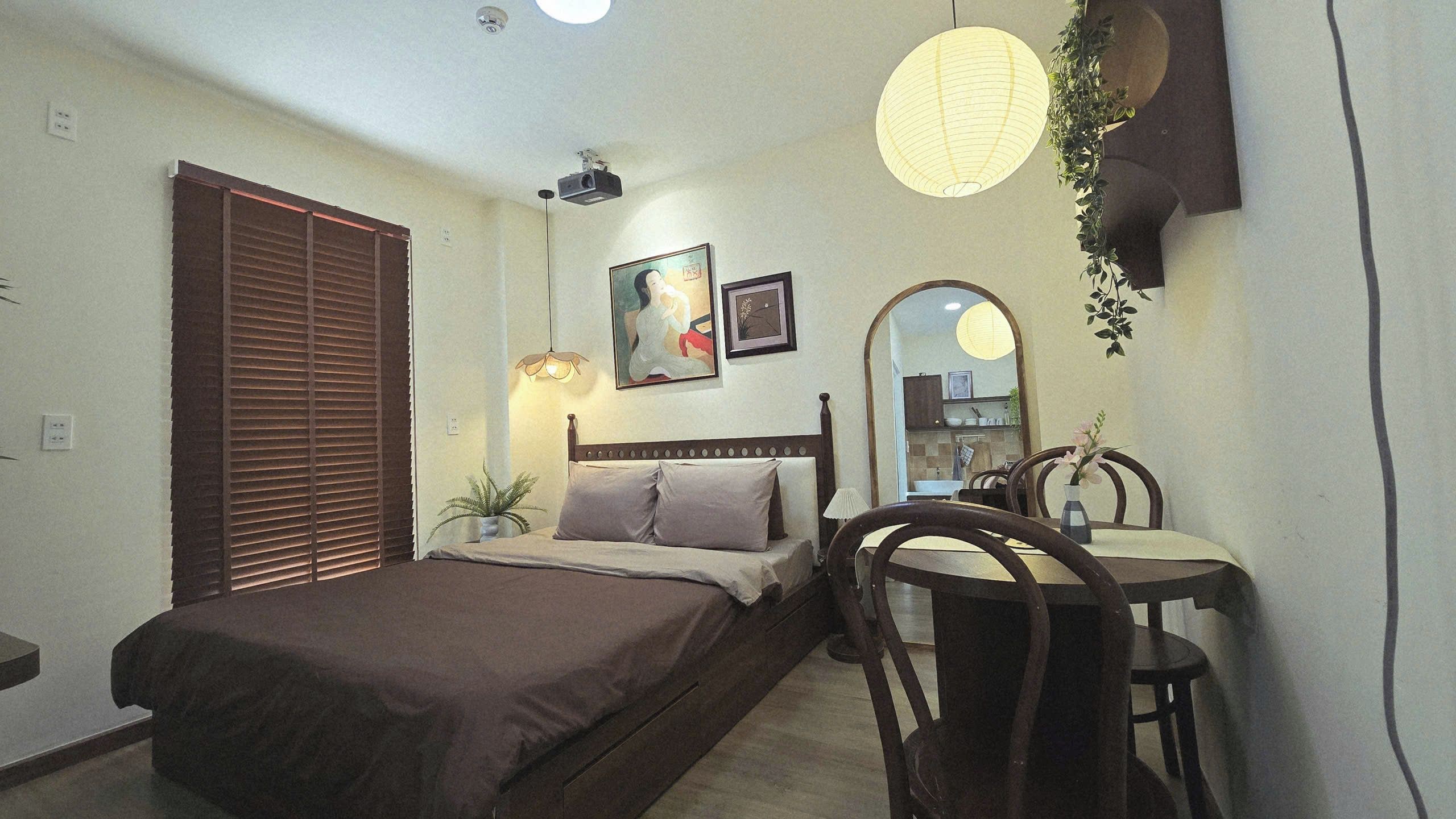 Ein Schlafzimmer mit Bett, Nachttisch, Lampe und Spiegel.