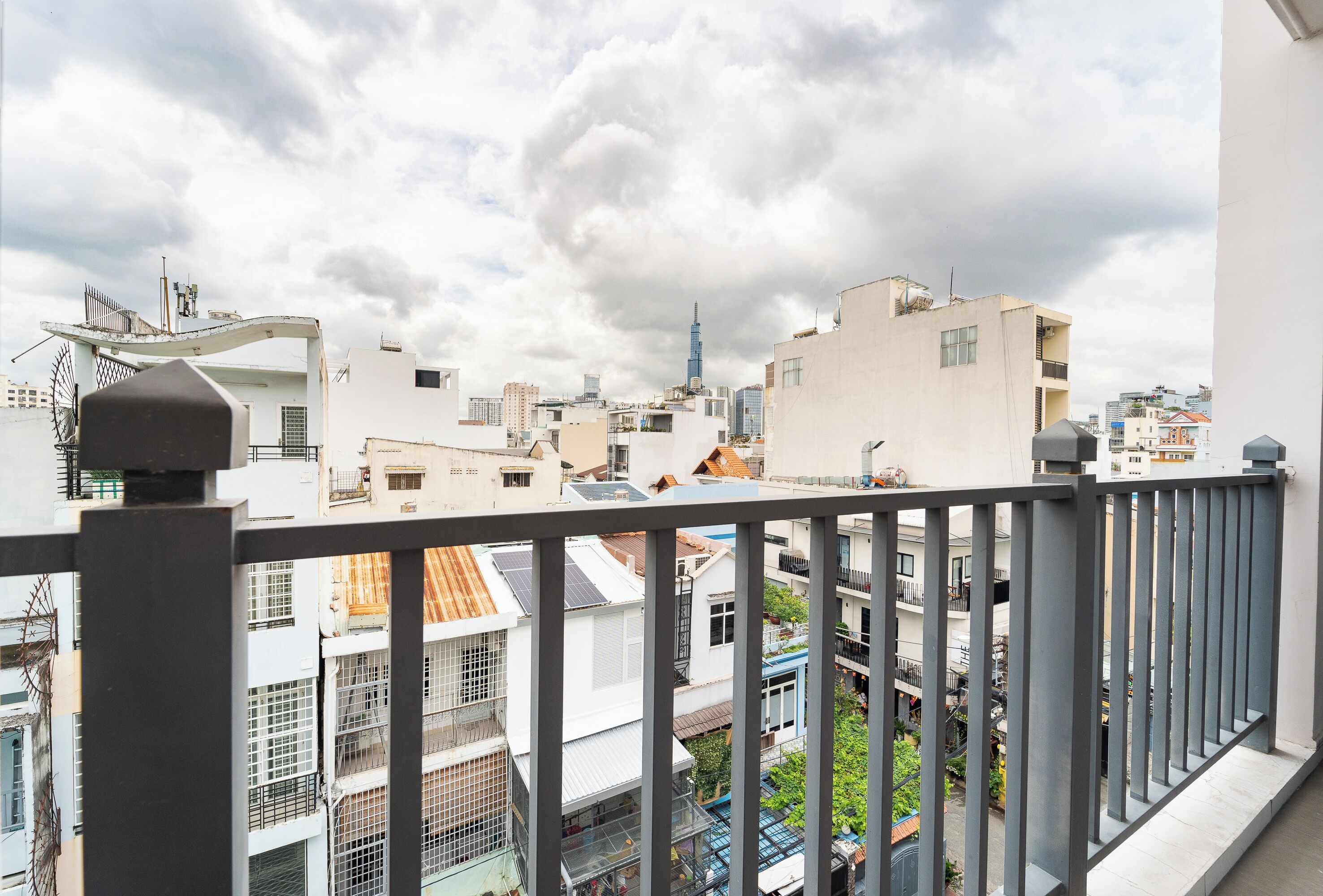 A cityscape with a variety of building styles, including modern and older structures, under a cloudy sky.