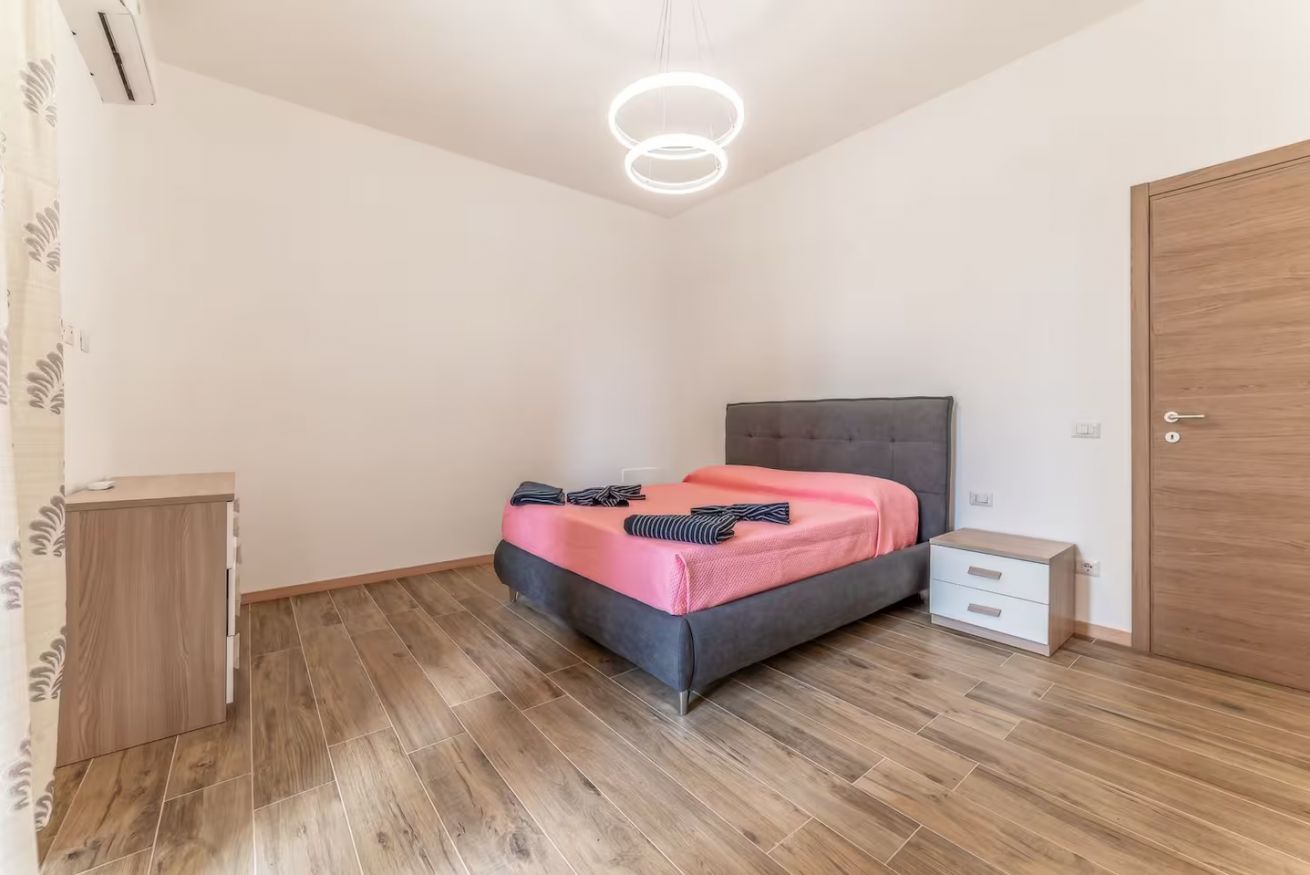 Ein Schlafzimmer mit einem Bett, einem Nachttisch und einem Kleiderschrank.
