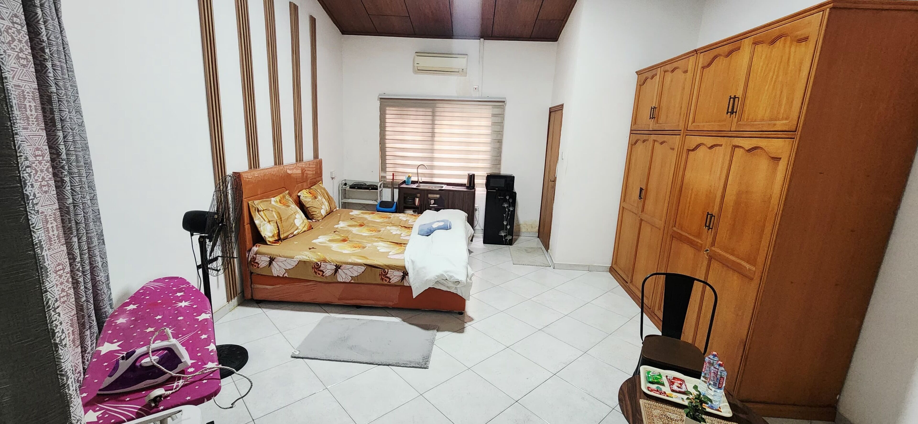 Een slaapkamer met een bed, een kledingkast, een bureau en een stoel.
