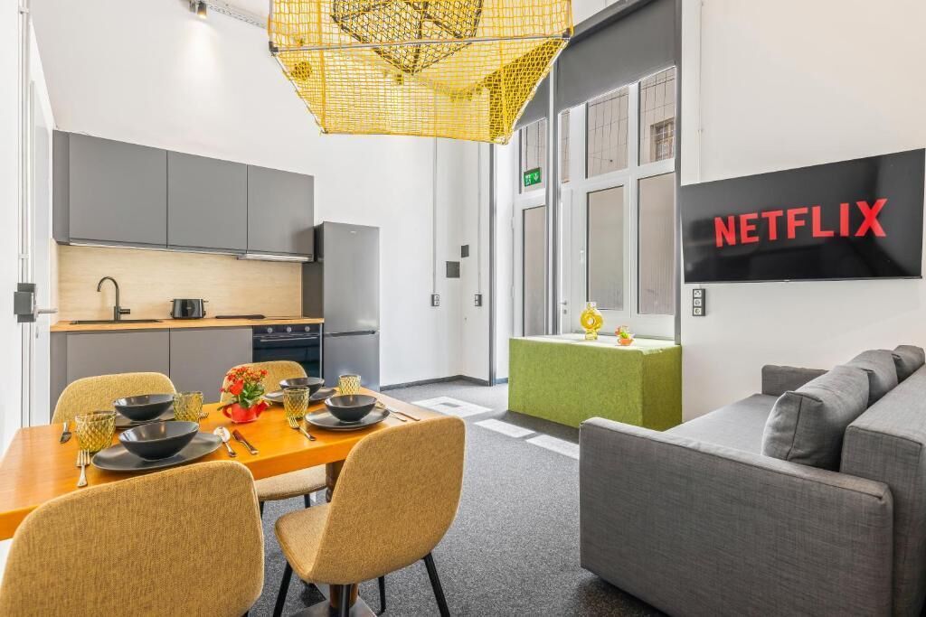 En modern inredning med ett matområde, ett litet kök och ett vardagsrum med en Netflix-skylt.