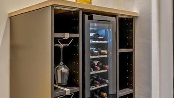Un mueble esquinero con varios compartimentos, que incluye un botellero y estantes para botellas.
