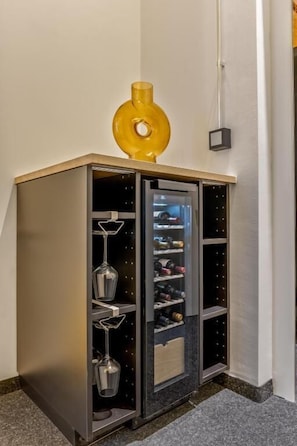 A corner storage unit with multiple compartments, including a wine rack and shelves for bottles. - cityswap Apartments City Center (Wien)