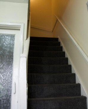 Eine Treppe mit Teppichstufen, die zu einer Zwischenebene führt.