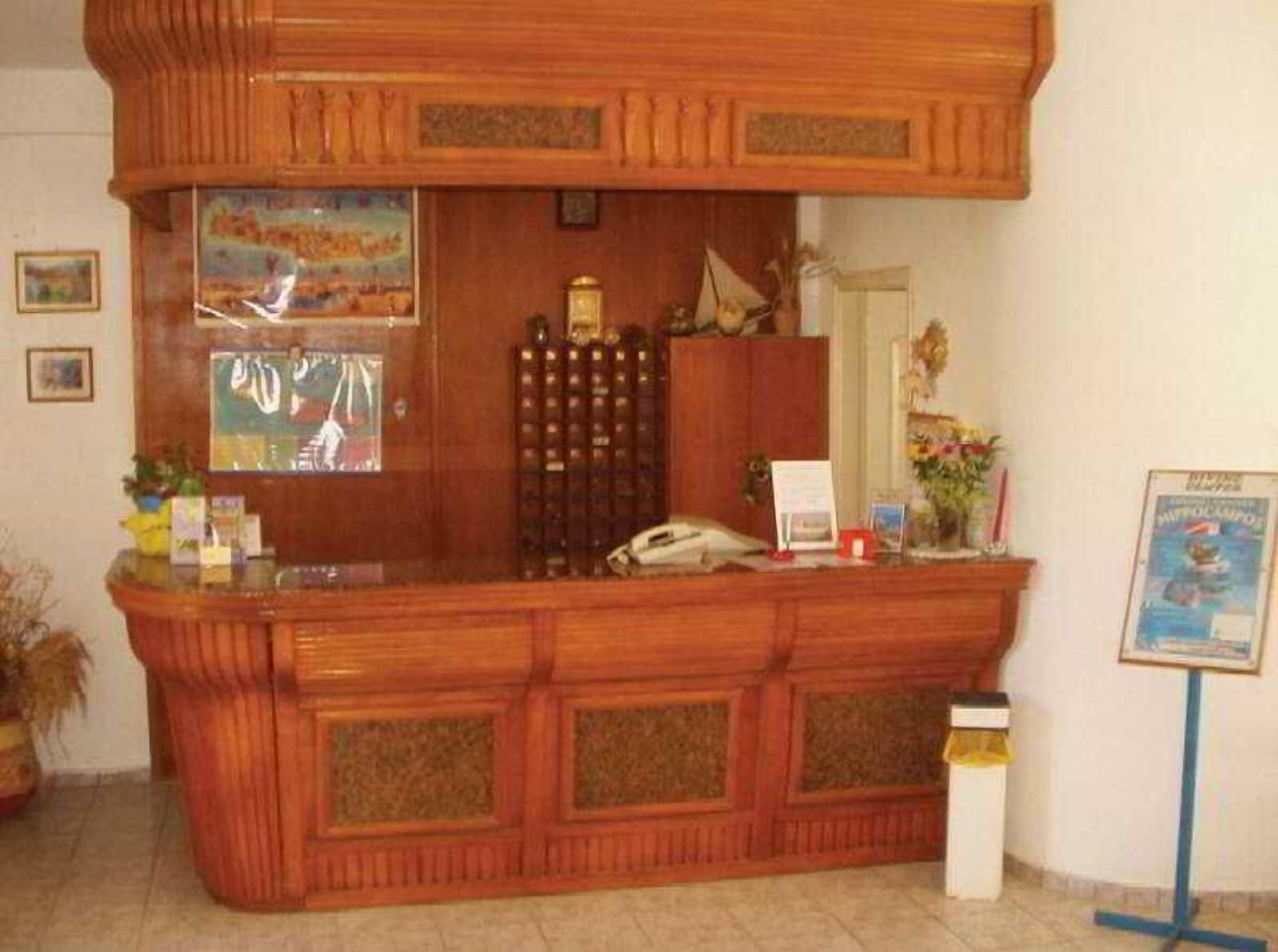A reception desk with a telephone, a framed picture, and a small plant.