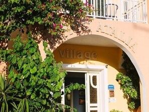 A building entrance with an archway labeled 'ATALLIA' and the word 'village' below it. - Ormos Atalia Village (Mylopotamos)