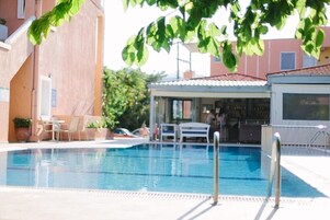 Piscina con área de bar y asientos al aire libre.