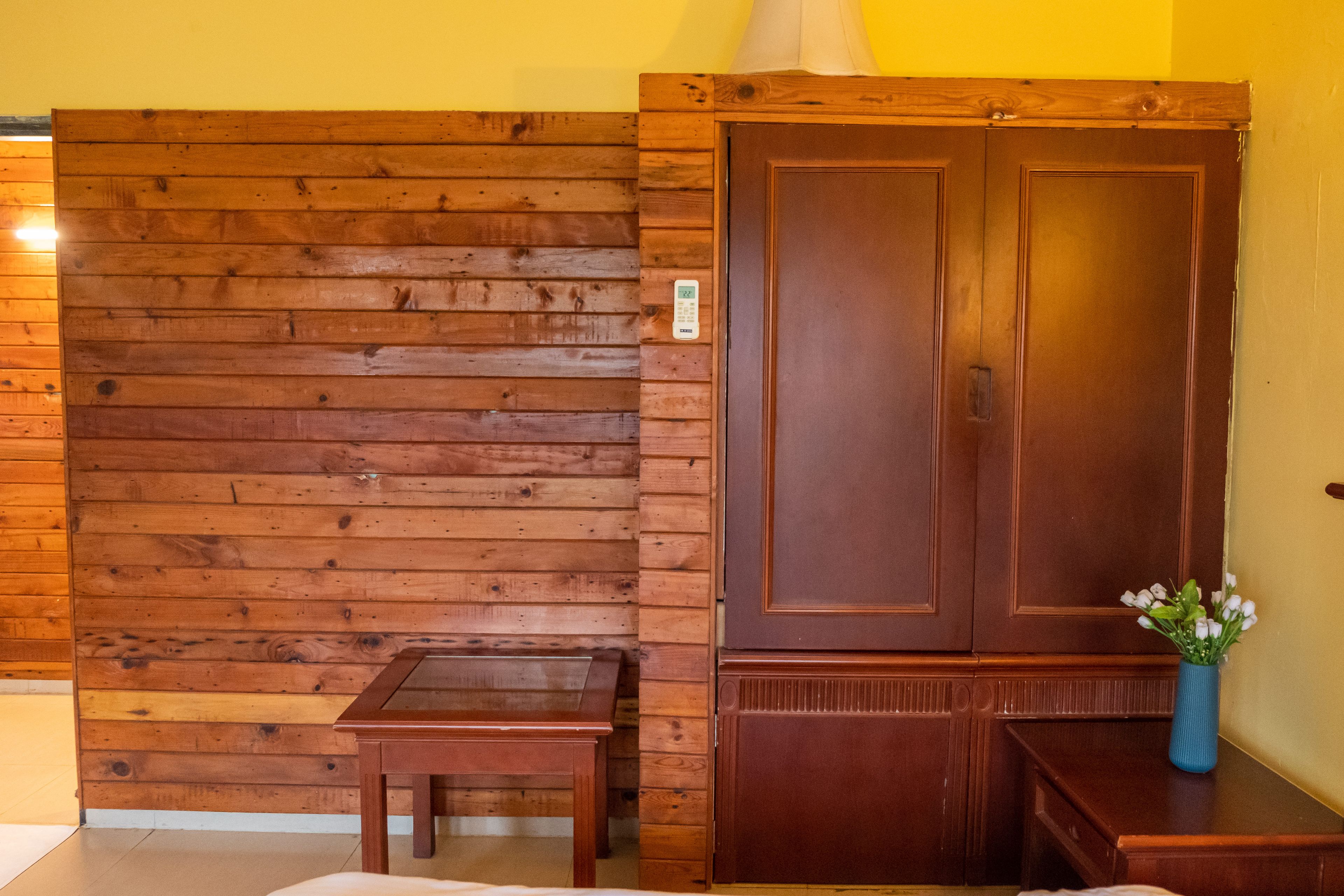 A wooden wall with a door and a small table.