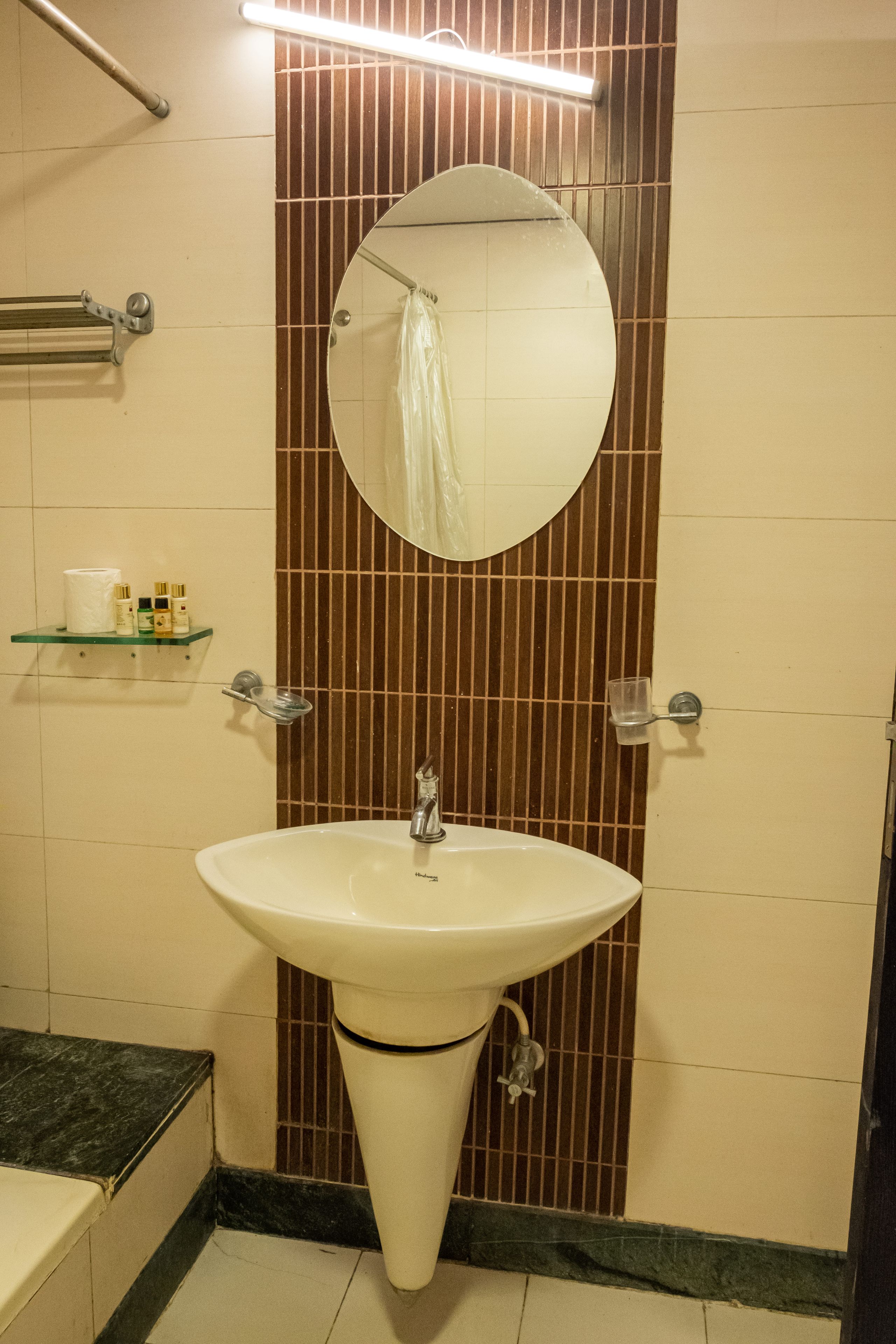 Ein Badezimmer mit Waschbecken, Spiegel und Handtuchhalter.