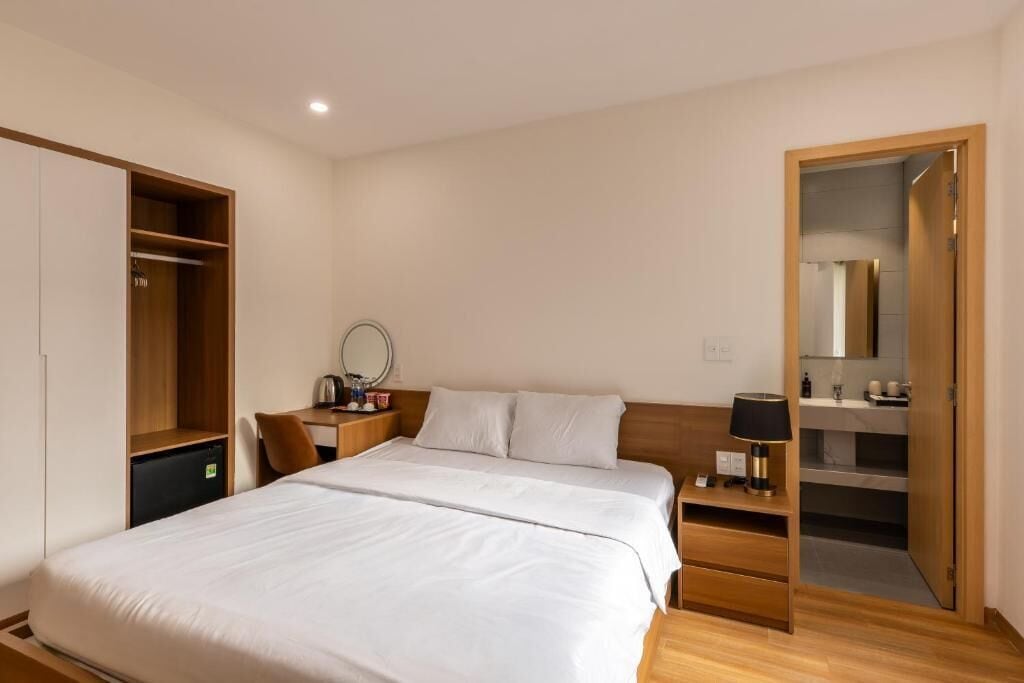 Une chambre d’hôtel comprenant un lit, un bureau, une armoire et une salle de bain.