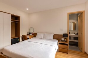 A hotel room with a bed, a desk, a wardrobe, and a bathroom. - Bluzen Hotel (Da Nang)