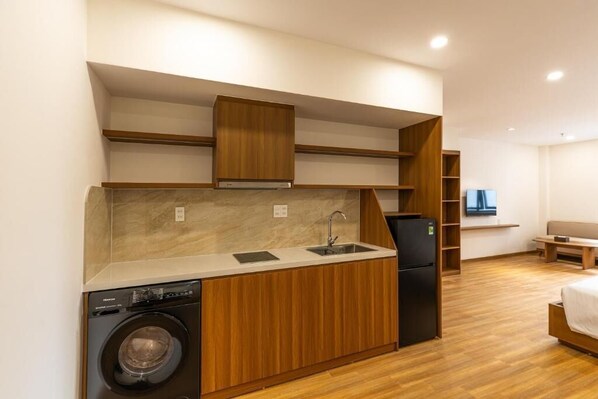 Cocina compacta con lavadora, lavaplatos y refrigerador.