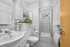 A modern bathroom with a sink, toilet, and shower. - Modern beachfront apartment with exceptional sea views at Schönberger Strand (Schönberg (Holstein))