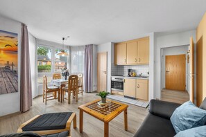 Un appartement moderne comprenant un coin repas, une cuisine et un salon.