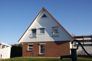 Einbungalow mit roter Backsteinfassade und weißem Dach.