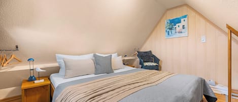 A bedroom with a bed, nightstands, a lamp, a chair, and a painting on the wall.