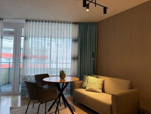 A modern living room with a sofa, a round table, and a chair. - Romantic lakeside cabin with a balcony and indoor communal pool in Uhldingen-Mühlhof (Uhldingen-Mühlhofen)