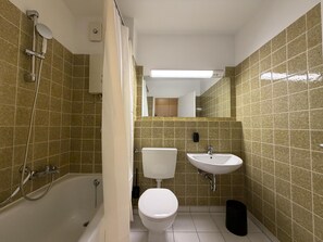 A bathroom with a bathtub, toilet, and sink, all with modern fixtures. - Romantic lakeside cabin with a balcony and indoor communal pool in Uhldingen-Mühlhof (Uhldingen-Mühlhofen)
