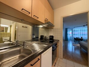 A modern kitchen with stainless steel appliances, a built-in oven, and a dining area with a table and chairs. - Romantic lakeside cabin with a balcony and indoor communal pool in Uhldingen-Mühlhof (Uhldingen-Mühlhofen)