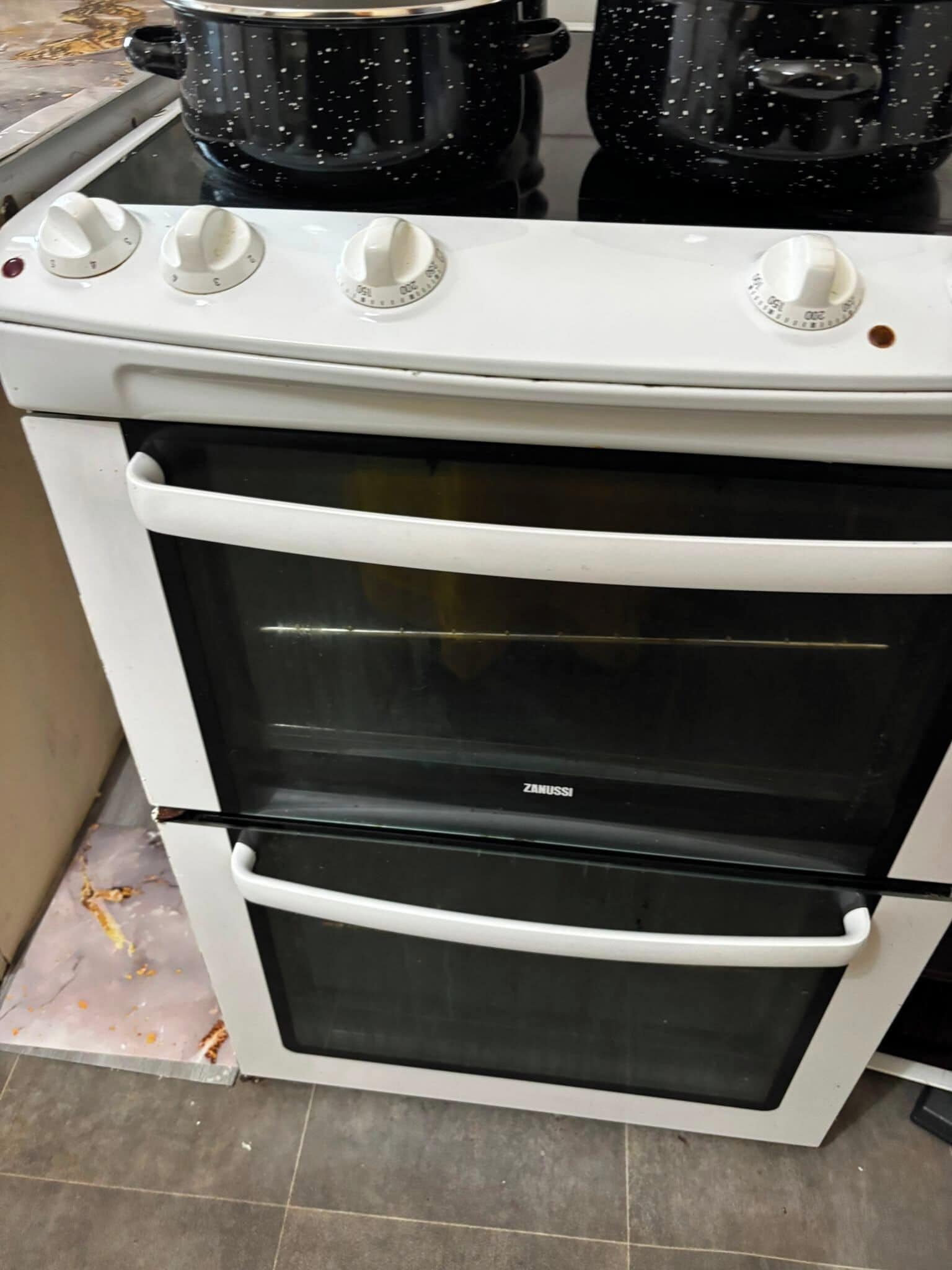 Un horno Zanussi con exterior blanco, dos mandos y una puerta de cristal.
