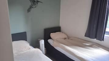 Un dormitorio con dos camas, un calentador y una decoración en la pared.