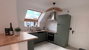 A kitchen with a skylight, a built-in oven, and a trash bin. - Charming house near the ocean and the village (Hillion)