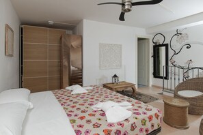 Une chambre d’hôtel comprenant un lit, une armoire, une petite table avec une lampe, une chaise et un miroir décoratif.