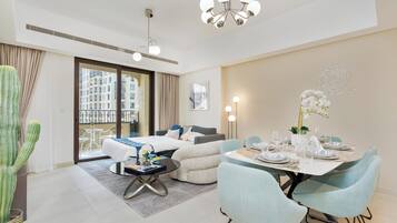 A modern hotel room with a balcony, a dining area, and a living space.
