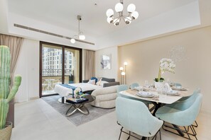 A modern hotel room with a balcony, a dining area, and a living space. - bnbme - Al Jazi - 2BR (Dubai)