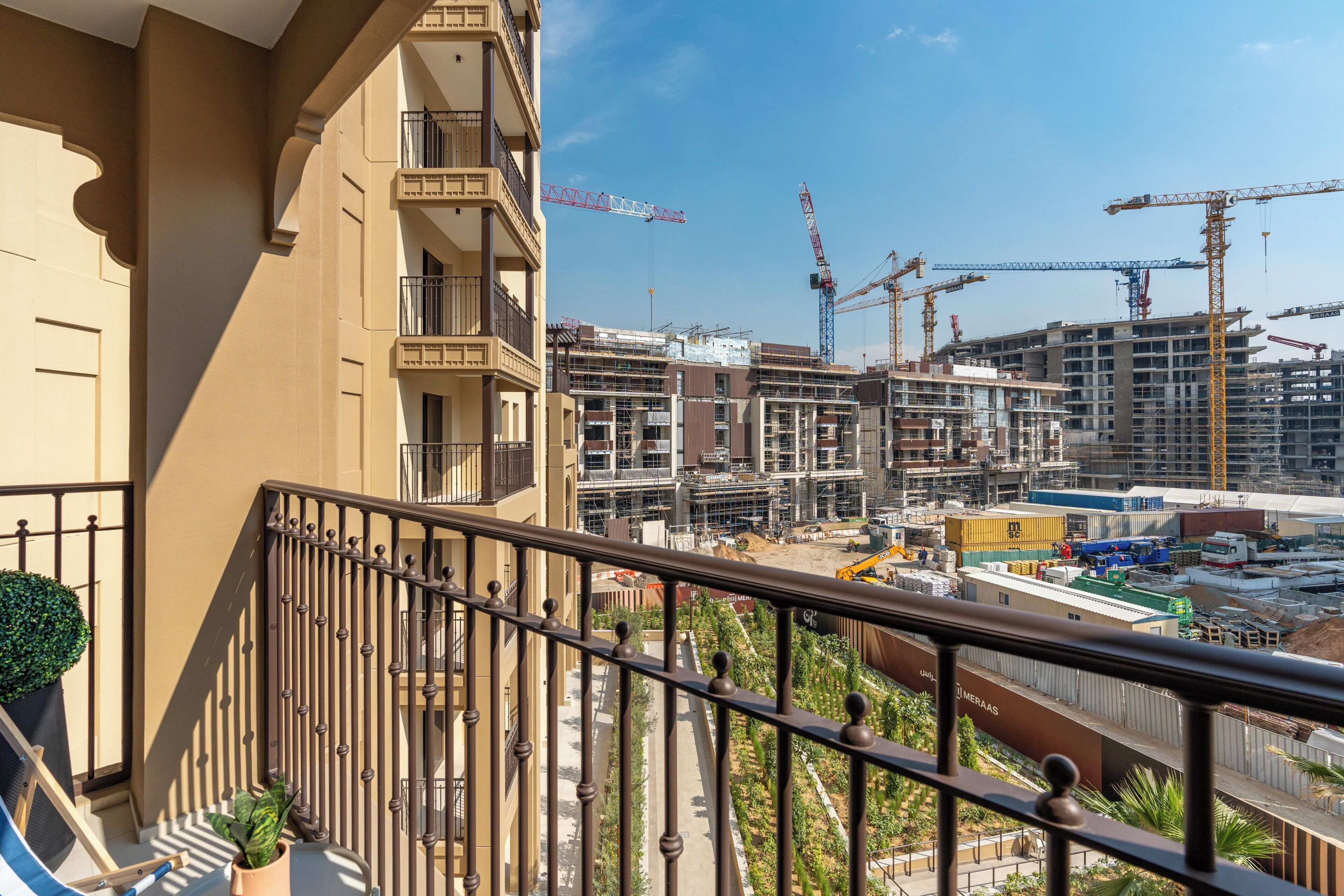 A balcony with a view of a construction site and surrounding buildings.