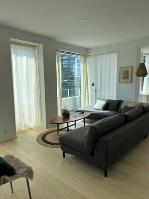 A modern living room with a sofa, a coffee table, and a lamp.