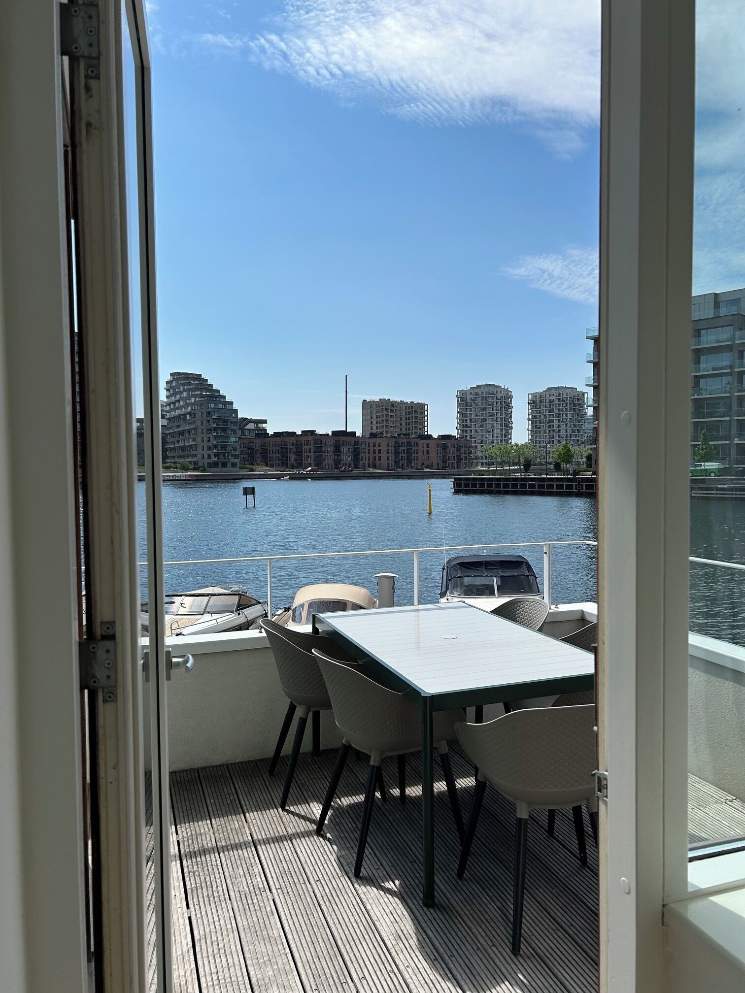 A balcony with a view of a river and buildings across it.
