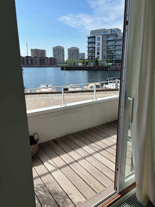 A balcony with a view of a marina and buildings across the water.
