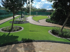 A landscaped outdoor area with exercise equipment, a curved pathway, and green spaces.
