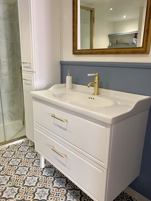 A bathroom with a white vanity, a gold faucet, and a mirror with a gold frame. - The "Belle Époque"-style house near the sea. Entire apartment. (Saint-Hippolyte)