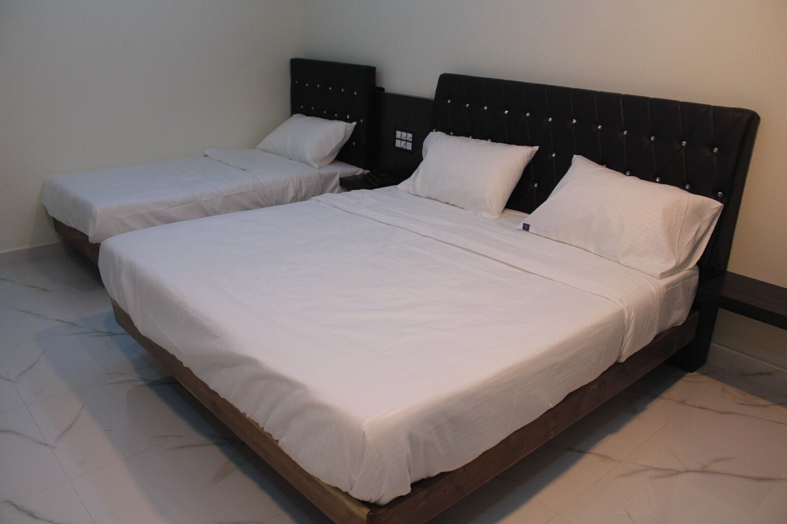 A double bed with a wooden frame and a headboard with a grid pattern.