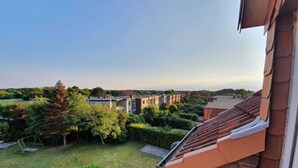Een woonwijk met uitzicht op omliggende huizen, een verzorgd gazon en een bakstenen gebouw met een pannendak.