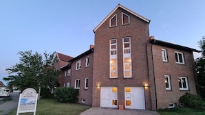 A two-story brick building with a symmetrical facade, large windows, and a central entrance. - Op'n Rugenbarg Vacation Rental Elbe H64 (Cuxhaven)