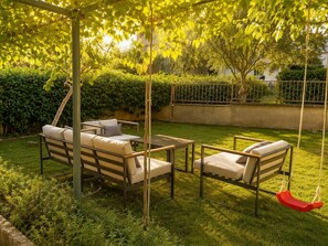 A patio with two sofas and a swing, surrounded by greenery. - Fortica Garden Apartment – Pula Arena, Free Parking (Pula)