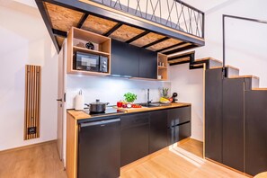 A compact kitchen with a built-in dishwasher, wooden countertops, and a black cabinet. - Alter 26 Urban Apartment With Free Parking (Koper)