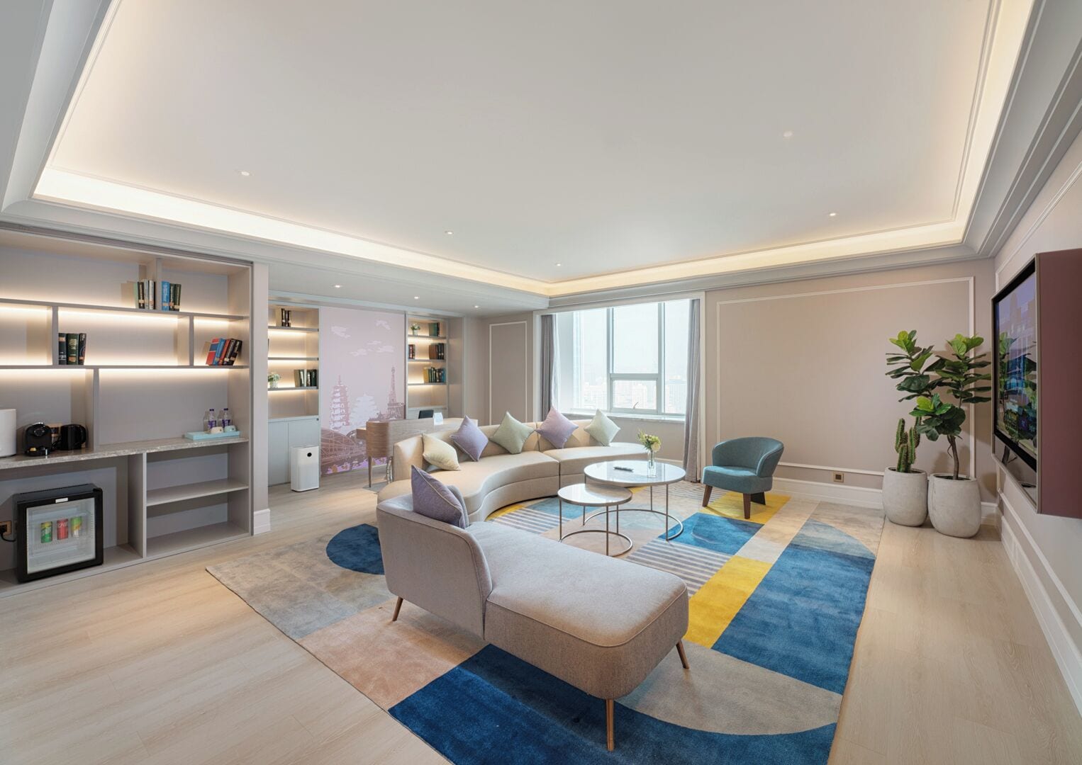 A modern living room with a sectional sofa, a coffee table, a small side table, and a bookshelf.