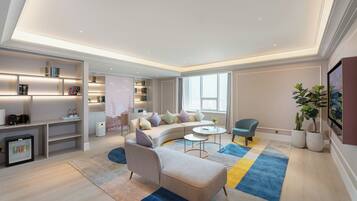 A modern living room with a sectional sofa, a coffee table, a small side table, and a bookshelf.