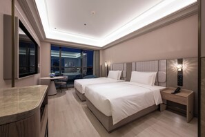 A modern hotel room with a large bed, bedside tables, a desk, and a view of the city at night. - Mercure Shanghai Lujiazui Binjiang Center (Shanghai)