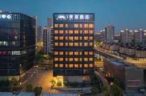 A modern hotel building with illuminated windows and a clear view of the surrounding cityscape. - Mercure Shanghai Lujiazui Binjiang Center (Shanghai)