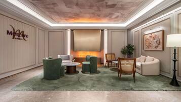 A hotel lobby with a seating area, a fireplace, and a wall-mounted artwork.