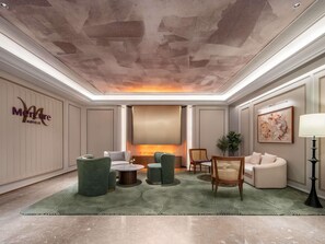 Eine Hotelhalle mit Sitzgelegenheiten, einem Kamin und einem an der Wand befestigten Kunstwerk.