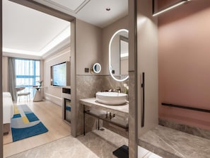 Un baño moderno con un espejo grande, un espejo redondo y un lavabo blanco.